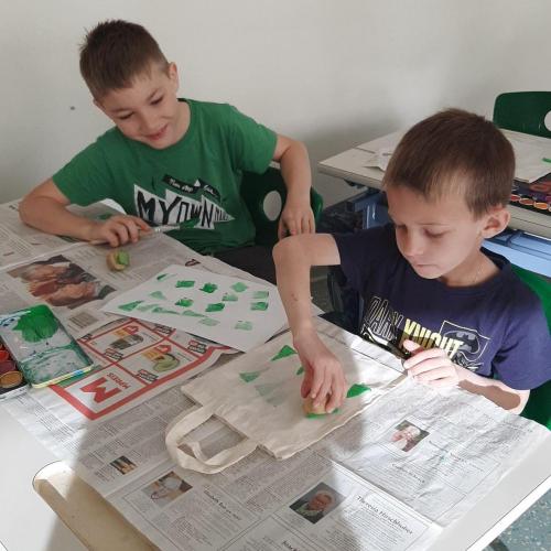 zwei Kinder bedrucken eine Tasche