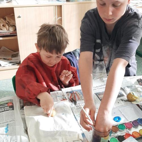 zwei Kinder bedrucken eine Tasche