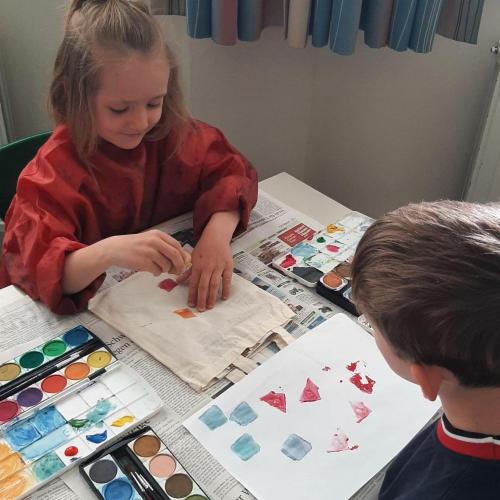 zwei Kinder bedrucken eine Tasche