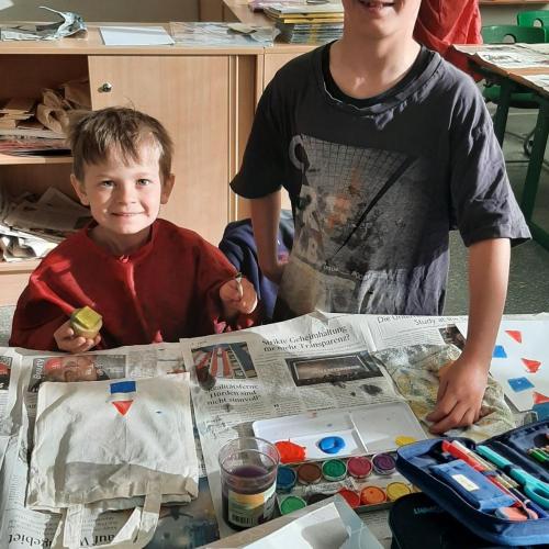 zwei Kinder bedrucken eine Tasche