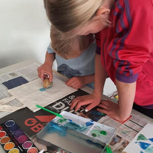 zwei Kinder bedrucken eine Tasche